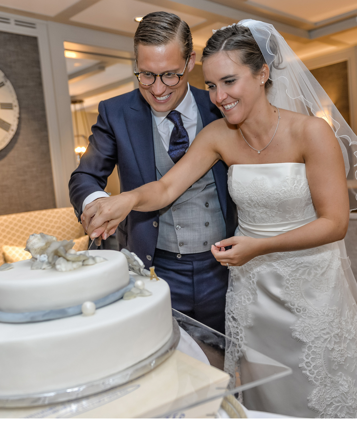 Brautpaar schneidet die Hochzeitstorte an im Sylter Restaurant Tipken's in der Guten Stube Bride and groom cutting the wedding cake at the elegant Hotel Severin*s Resort & Spa on Sylt.