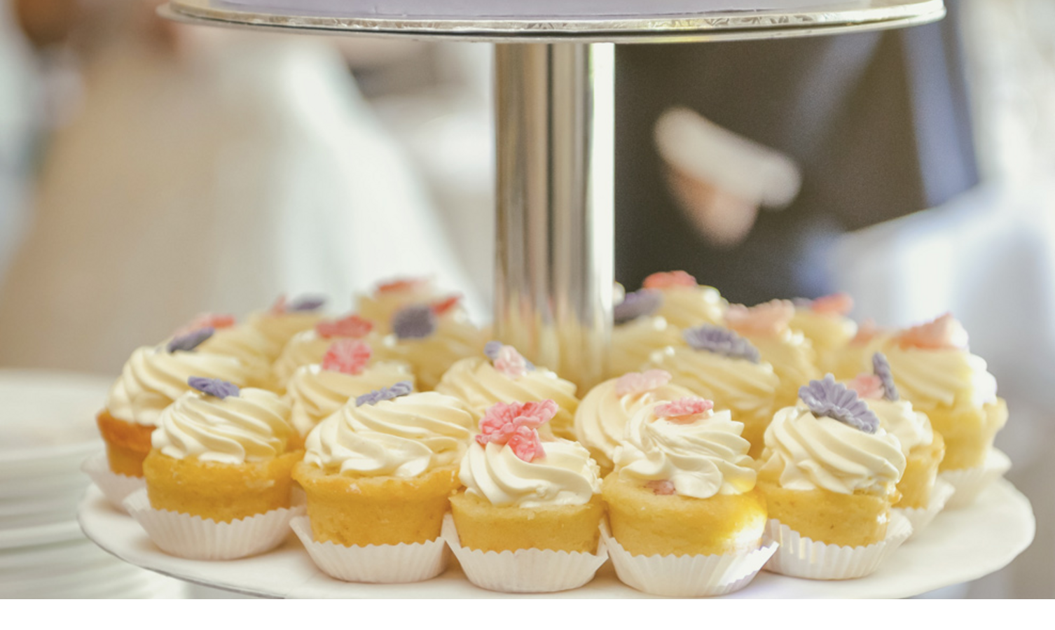 Hochzeitstorte aus der Patisserie des Hotel Severin*s Resort und Spa auf Sylt Etagere with wedding cake and cupcakes, decorated with colorful flowers, at Severin*s Resort & Spa on Sylt.